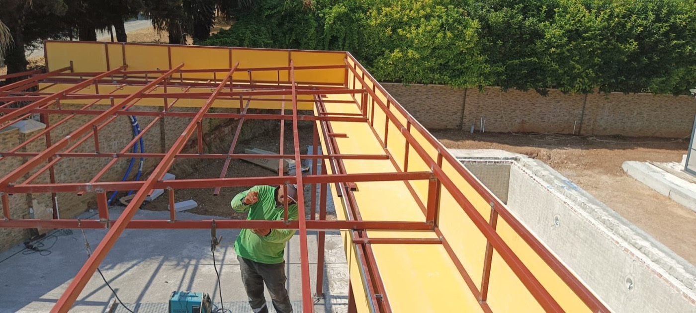 Çelik çatı üzerinde sandviç panel montajı yapan usta